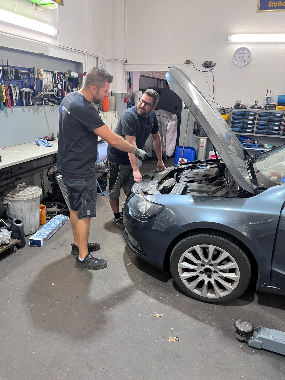 Kfz Döring - Automobil Reparatur, Wartung oder Inspektion -Ehrliche Beratung – Zwei Mechaniker arbeiten an einer Autoreparatur